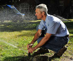 an Oakville irrigation system specialist inspects a head